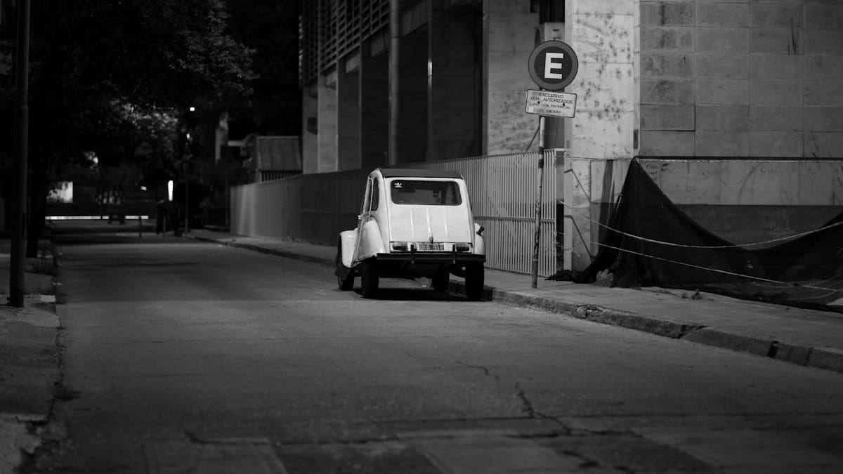 Black and white photo of a vintage Citroën parked on a quiet street in Córdoba, Argentina.